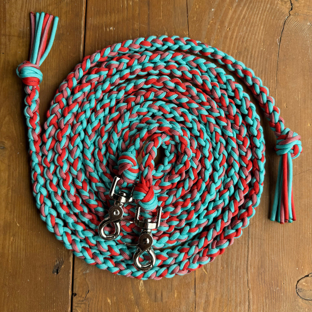 Red and blue braided rope with metal clips on a wooden surface